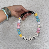  Custom beaded dog collar with pastel round and flower beads and DAISY name letters, showing a personalized design option for Willadore Collar Co.’s handmade beaded dog collars