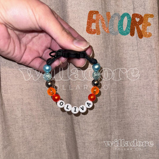 Custom beaded breakaway cat collar with multicolor beads and OLIVA name letters, showing a personalized safety‑focused design option from Willadore Collar Co.