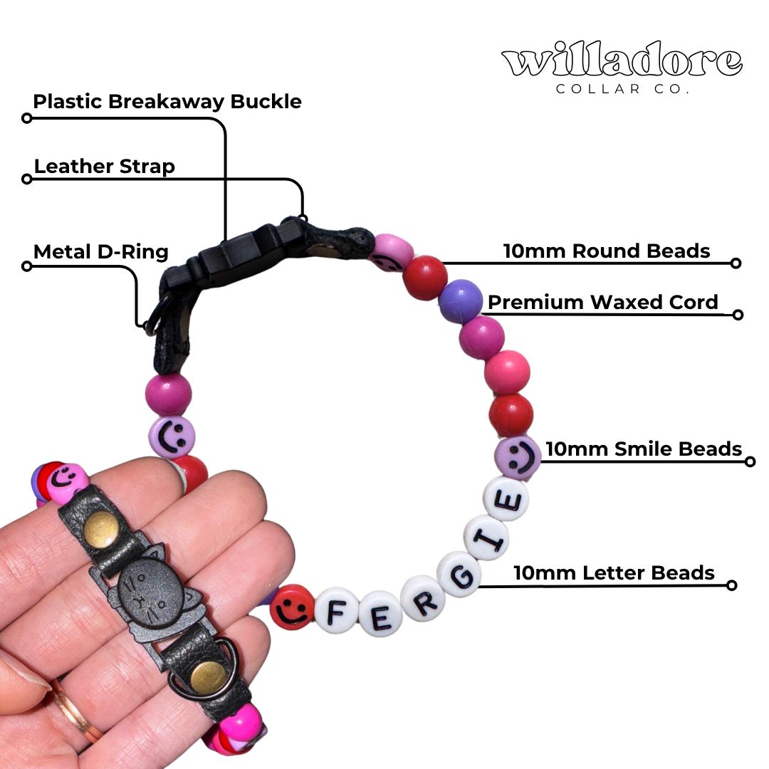 Labeled diagram of a custom beaded breakaway cat collar with multicolor beads, smile beads, and FERGIE name letters, showing key components and safety‑focused construction details for Willadore Collar Co.’s handmade cat collars.
