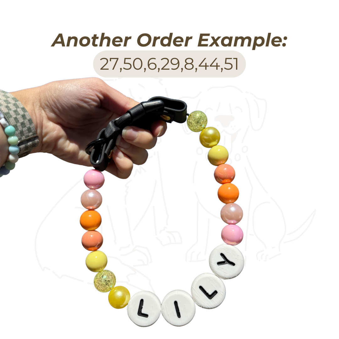 Hand holding a specialty custom beaded dog collar example with yellow, orange, pink, and gold sparkle beads plus name beads spelling “LILY,” showing a personalized order option from Willadore Collar Co.